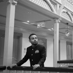 A handsome black and white portrait of the groom, looking thoughtful and elegant in his wedding attire. This shot captures a quiet moment of reflection.