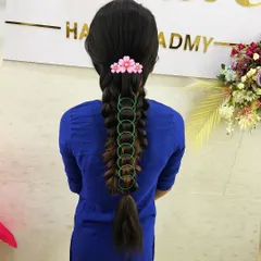 This infinity loop braid is a creative and modern style that students love to learn. It shows how simple accessories like rings and a floral clip can create a unique look.