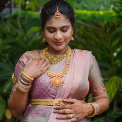 A solo portrait celebrating the mother-to-be. Her traditional gold jewelry and silk saree are highlighted against a lush green background, creating a timeless image of her pregnancy journey.