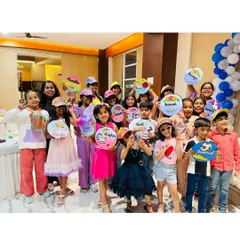 A party full of little artists. Here, a group of friends proudly holds up the personalized plates and caps they designed. Every child gets to take home their creation as a unique party favor.