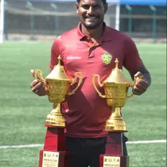 One of our senior coaches holding the Runners Up trophies from the WSM Blue Club League, representing our academy's consistent success.