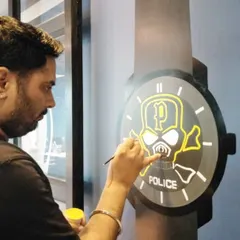 Police watch ke painted design par main small brush se skull aur outline ki details banata hoon.