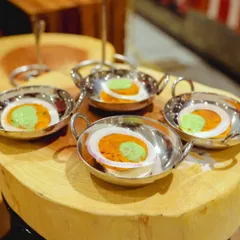 Experience melt-in-your-mouth perfection with our Mutton Galouti Kebabs. These delicately spiced patties are served on a bed of sliced onion with a dollop of mint chutney in individual steel bowls.