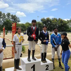 Our riders on the podium after a successful day at a show jumping competition. Every medal represents countless hours of hard work in the arena.