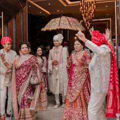 The groom's grand entrance, surrounded by his beautifully styled family. Notice how the colours and styles of the mother's saree, sister's lehenga, and father's outfit all complement each other without being identical, creating a rich, coordinated family portrait.
