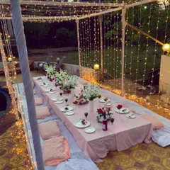 An intimate sit-down dinner arrangement for a bridal shower. I used low seating with cushions and a beautifully decorated long table under a canopy of fairy lights.