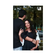 A tender moment between the couple during their outdoor maternity session, with the father-to-be gently holding his partner.