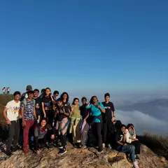 A group of college students celebrating their successful climb to the summit, high above the clouds. The sense of accomplishment is a powerful part of our leadership treks.