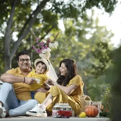 A perfect family day out. This outdoor picnic setup with warm, golden light captures a relaxed and happy family moment.