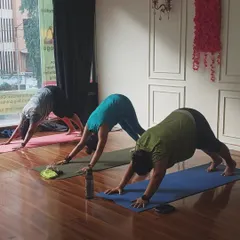 Proper alignment is key. Here, my students are in Adho Mukha Svanasana, or Downward-Facing Dog, focusing on lengthening their spines and opening their shoulders.