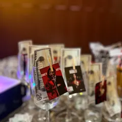Setting the scene for a Money Heist themed party with custom tags and faux money clipped to the glassware.