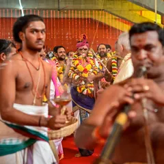 A procession during the Rishi Homa. The priests carry sacred items with reverence, and the air is filled with the sound of traditional music and chants.