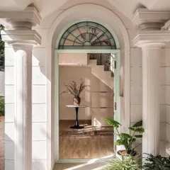 The grand entrance of the Ivy Lane Villa, as featured in AD. The publication noted the restored colonial columns and the captivating sage green hue of the custom arched door, which sets the tone for the home's blend of history and modern elegance.
