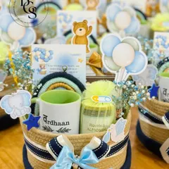 Announcing a new arrival is pure joy. This baby boy announcement hamper is designed to be as adorable as the little one, featuring a personalized mug, a jar of roasted almonds, and cute themed decorations like a rainbow and teddy bear cutouts, all arranged in a charming rope basket.