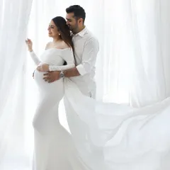 A stunning portrait of the expecting couple. The way he holds her as they stand by the window, wrapped in light and flowing white fabric, is pure romance and partnership.