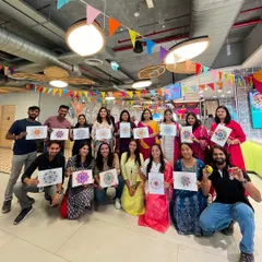 A happy team proudly displaying their colorful mandalas after a corporate session. It's so rewarding to see colleagues connect and create together, each with their unique artwork.