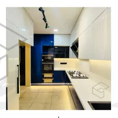 Another angle of the blue and white kitchen, highlighting the tall unit with built-in ovens and pull-out wicker baskets for vegetable storage. The handleless design on the lower cabinets keeps the look clean and contemporary.