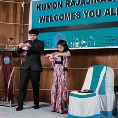 A young girl assists me with a trick on stage at a Kumon event. My interactive performances are great for educational events and workshops, encouraging participation and confidence.