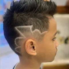 Another view of this awesome hair design. The combination of a spiky top and sharp side pattern makes for a super cool and modern kid's style.