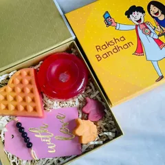 A fun Raksha Bandhan hamper designed for a little brother. This box includes a waffle soap, a donut soap, and mini unicorn soaps, along with a 'With Love' tag and rakhi.