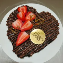 This heart-shaped brownie is perfect for an anniversary. It's topped with a chocolate drizzle, fresh strawberries, and a custom gold "Happy Anniversary" plaque.