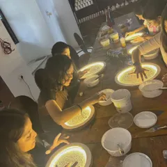 Students deeply engaged in our moon lamp workshop, carefully applying texture paste to create the moon's surface.