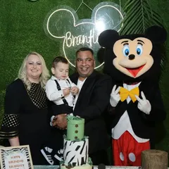A happy family posing with Mickey Mouse at their son's jungle safari birthday. I can arrange for live characters and mascots to interact with guests and make the party even more special.