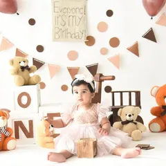 Posed and ready for her first birthday celebration. This shot shows off her beautiful dress and the adorable, classic teddy bear theme we created in the studio.