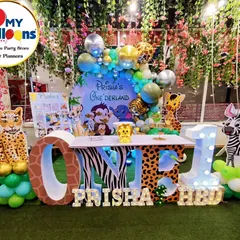 We transformed this space into a lush jungle for Prisha's "Onederland" party. The setup includes a large 'ONE' table with animal-print lettering, character cutouts of a leopard and zebra, and a backdrop of hanging foliage, creating a truly immersive wild animal adventure.