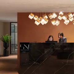 The reception at Jubilee Walk Headquarters, designed to be the first point of contact with the brand's ethos. The solid black marble desk, complemented by a cascade of geometric pendant lights, establishes an immediate sense of modern luxury and professionalism.