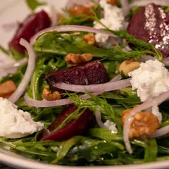 Our smoked beetroot salad, featuring earthy beets, crunchy walnuts, fresh arugula, and crumbles of our house-made ricotta cheese. A healthy and flavorful option.