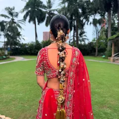 For this bride, we created a statement look with a traditional long braid, or 'choti', heavily adorned with stunning gold accessories. This style is perfect for framing an ornate lehenga and ensuring you look regal from every angle.