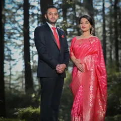 A classic and formal pre-wedding portrait taken in a pine forest. The soft, filtered light through the trees creates a timeless and romantic atmosphere, perfect for capturing a poised and elegant couple's photograph.
