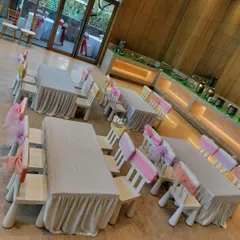Simple and sweet. These kid-sized tables are covered in white linen, with chairs decorated with pretty pink and yellow sashes.