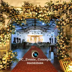 An elegant floral archway creates a grand entrance for a Holy Communion celebration. The red carpet and lush white and gold flowers set a formal and celebratory tone.