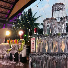 A pyramid of glasses stands ready on the bar, reflecting the ambient light. This artistic arrangement is part of the visual appeal we bring to our mobile bar service.
