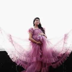 This gorgeous client is wearing a vibrant pink ruffled gown, with the layers of tulle creating a beautiful, wing-like effect. It's a perfect dress for feeling like a queen.