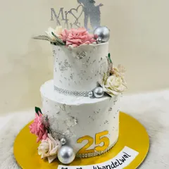 Celebrating 25 years of love with this silver anniversary cake. This two-tiered design features silver leaf, delicate flowers, and a "Mr & Mrs" topper.