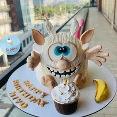 I love creating cakes based on beloved characters, like this one of Booba for Miyo's birthday. The entire cake is an edible sculpture, showcasing detailed fondant work, and is paired with a matching cupcake to complete the celebration.