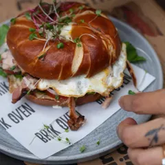Our signature pretzel bagel sandwich, filled with smoked ham, a fried egg, and fresh microgreens. The pretzel bagel adds a unique chewy texture and savory flavor.