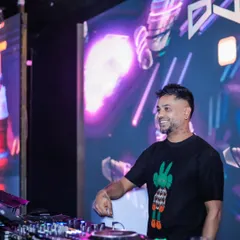 Here I am at the decks with a massive LED screen behind me displaying abstract, colorful visuals. This is a core part of my VJ service, turning the DJ booth into a visual centerpiece.