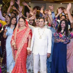 A high-energy group photo with all the guests waving and celebrating the happy couple.
