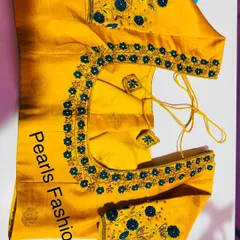 A mustard yellow blouse with blue floral threadwork. The flowers are placed along the neckline and scattered on the sleeves, with matching latkans.