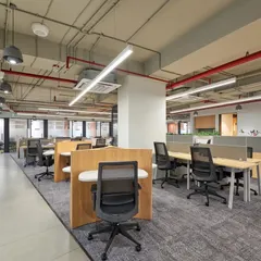 An open office environment with a mix of workstation configurations. The design uses low wooden partitions to create a sense of personal space without sacrificing the open feel.