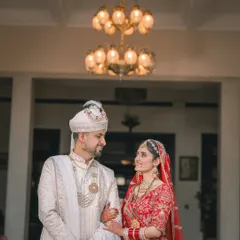 The couple sharing a sweet glance under a grand chandelier, a classic portrait from their wedding day.