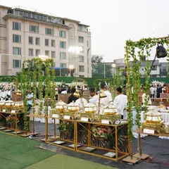 An outdoor event calls for a fresh and elegant setup. Here, I used golden stands and green vine accents to create a beautiful garden party feel, with our professional staff ready to serve.