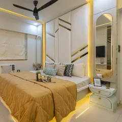 Luxury is in the details. This master bedroom features a custom padded headboard with gold inlay, complemented by warm ambient lighting from below the bed and within the side mirror panel, creating a very high-end hotel feel.