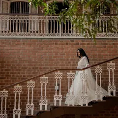 A vision in white. This bride's elegant Tarun Tahiliani lehenga looks absolutely stunning against the rustic brick backdrop, creating a timeless and regal bridal portrait.