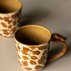 This mug features a beautiful leaf pattern created using the Mishima inlay technique. We carve the design into the clay and fill it with a colored slip, resulting in a clean, crisp pattern.