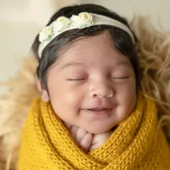 A peaceful newborn wrapped snugly in a yellow knit blanket, dreaming sweetly. I use soft textures and warm colors to create cozy and artistic newborn portraits.